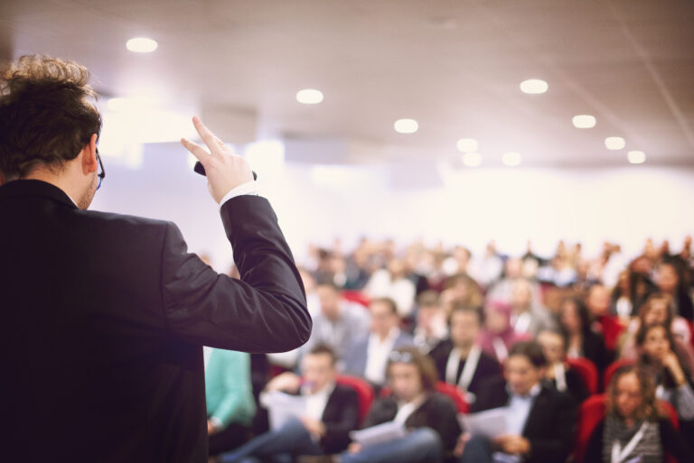 A speaker delivers a conference speech to an audience