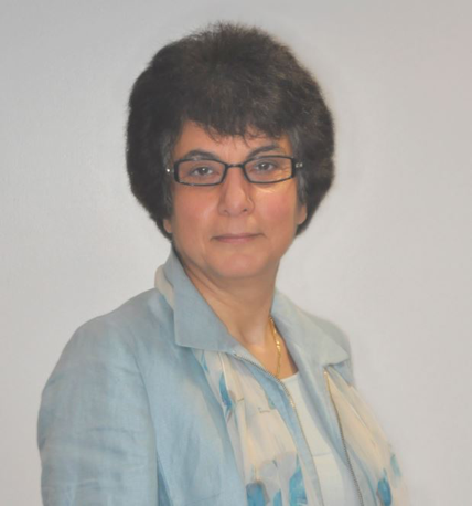 Portrait of a woman wearing glasses and a light blue jacket, facing the camera.