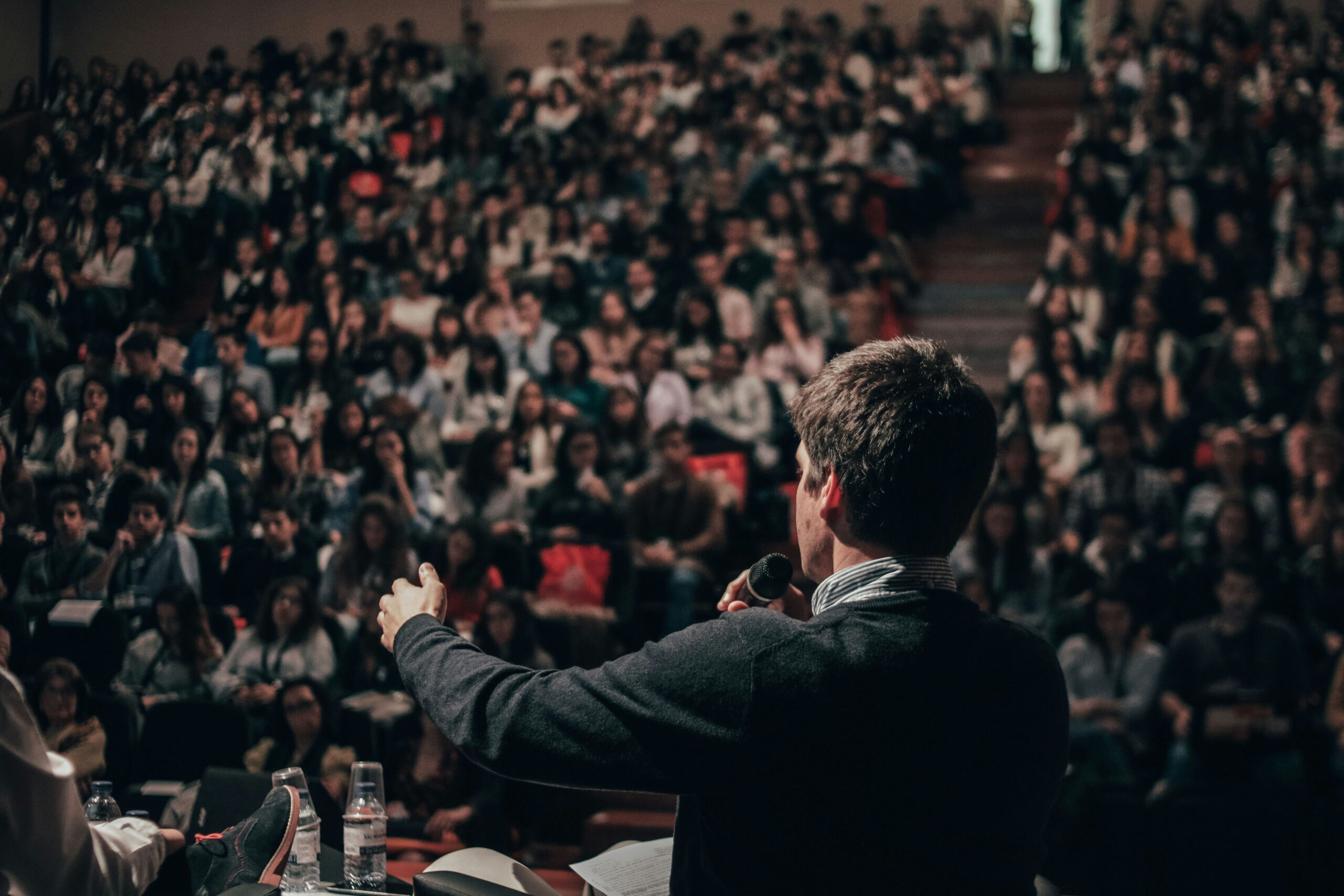 A male presenter speaks in a lecture theatre